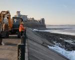 workmen stood on the walkway at Marine Lake in Weston-super-Mare looking out to sea