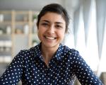 woman sat at a table smiling towards the camera