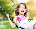 young girl on a swing with a big smile on her face