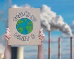 cardboard sign held up outside a power station that reads 'there's no planet B'