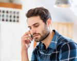man in a blue checked shirt talking on the phone