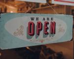 shop sign in a window that says 'we are open'