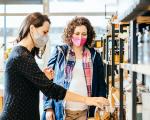 Two women wearing face masks while shopping