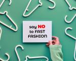 postcard saying 'say no to fast fashion'. background is light green with white coat hangers spread out around the postcard