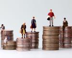 coins piled up with people stood on top of them