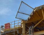 yellow metal with a net attached against a bright blue sky