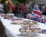 a long table set out for a street party. Table is covered by a white table cloth and on top are a selection of snacks and a Union Flag