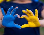 Childs hands in a heart shape - one blue and one yellow