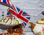 sandwiches on top of an afternoon tea stand with a Union flag in the background