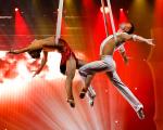 two dancers suspended on ropes in the air