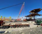 Body of the metal seamonster structure sits on Weston beach next to a crane