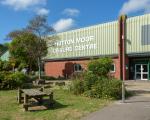 Hutton Moor Leisure Centre on a sunny day. A bench and trees are in front of the entrance