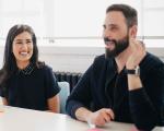a man and a woman smiling and talking in a meeting room