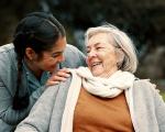 a female carer laughing with an older woman