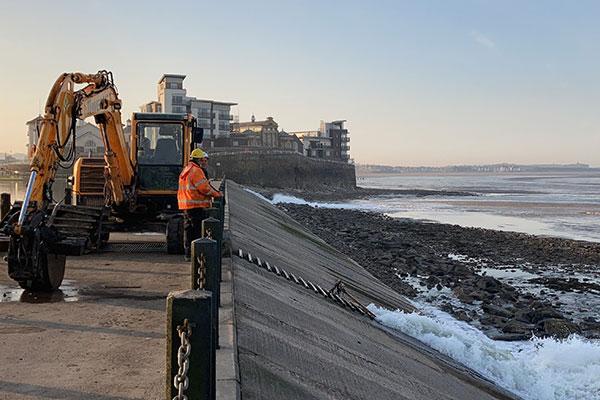 workmen stood on the walkway at Marine Lake in Weston-super-Mare looking out to sea