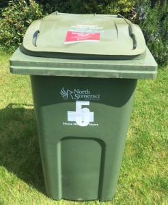 green garden waste bin with red permit stuck on the lid