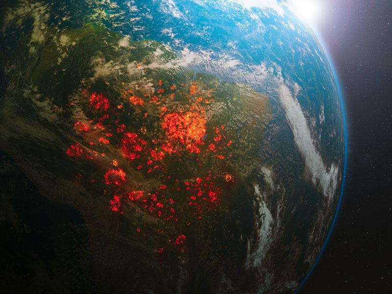 Image of the earth from space with glowing red and orange patches on the usually green landmasses