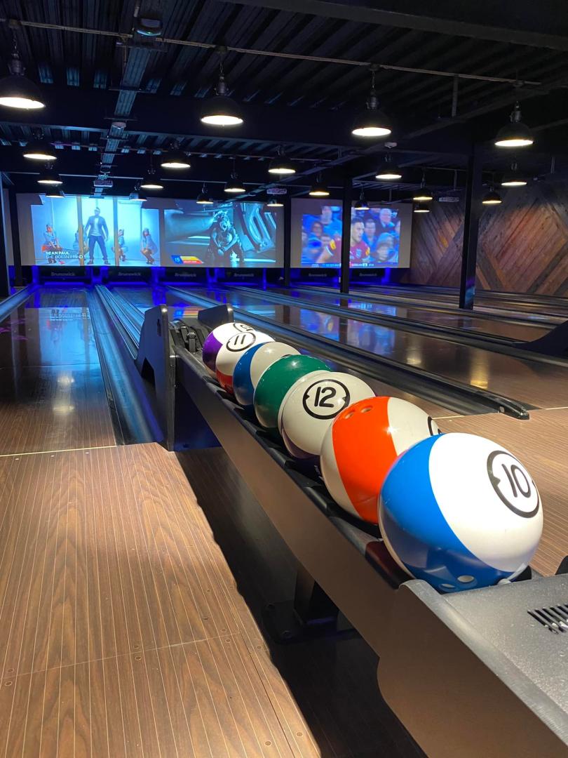 bowling balls lined up in front of a bowling lane