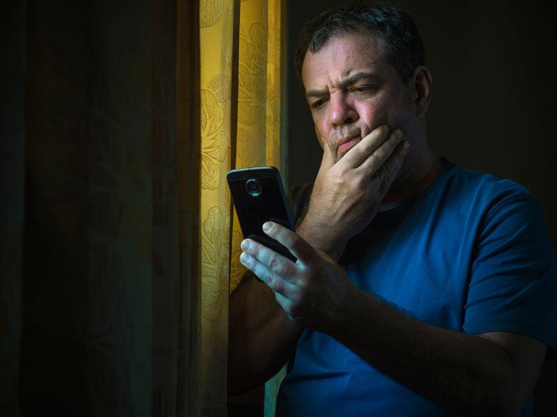 Man looking at smartphone, worried