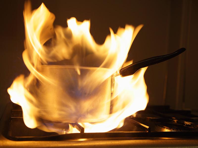 A pan on fire in a kitchen