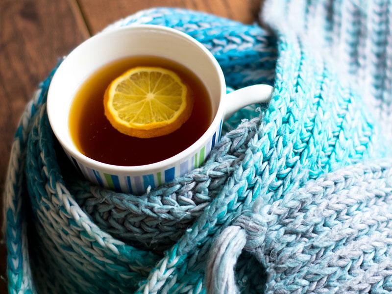 Mug of herbal tea wrapped in a scarf