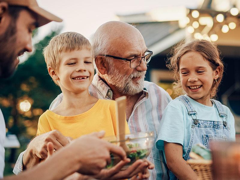 a grandfather and grandchildren smiling