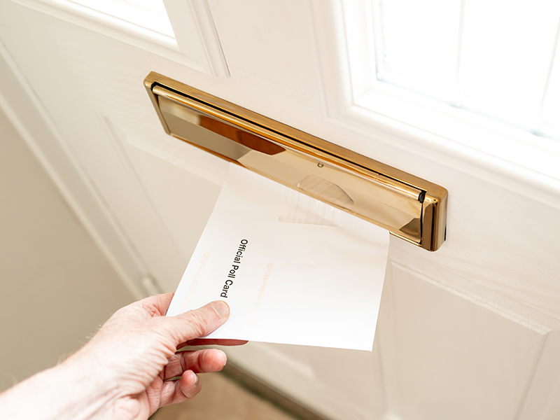 a postal vote coming through a letterbox