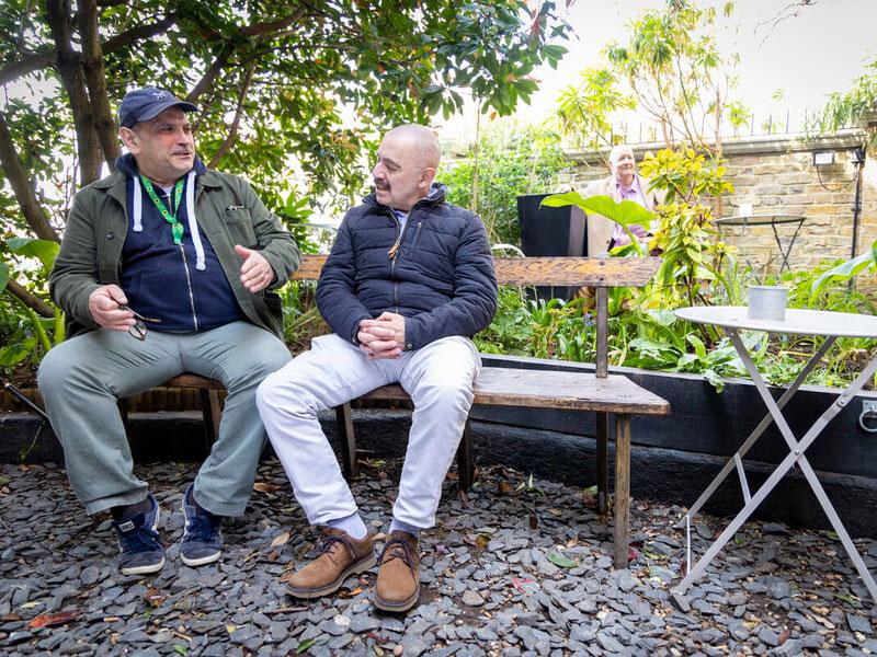 Two older men talking on a bench