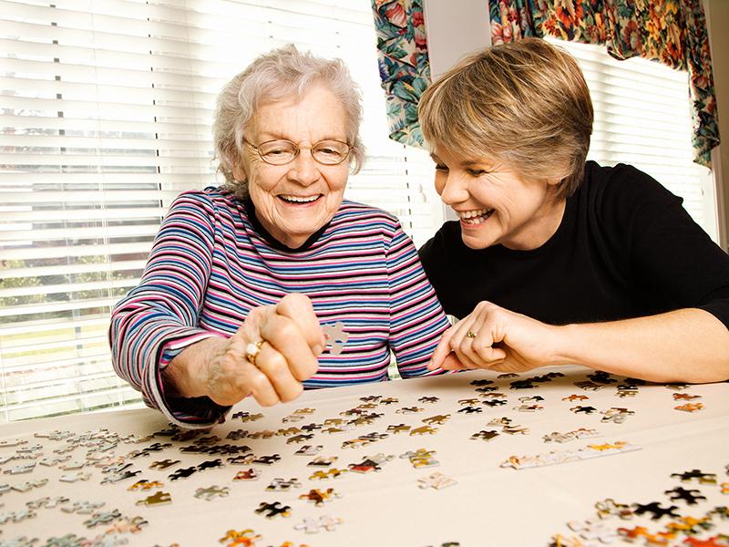 A younger and older woman doing a jigsaw