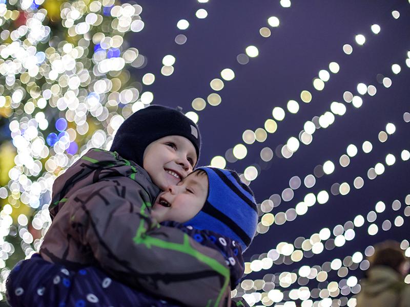 Two boys under sparkly Christmas lights