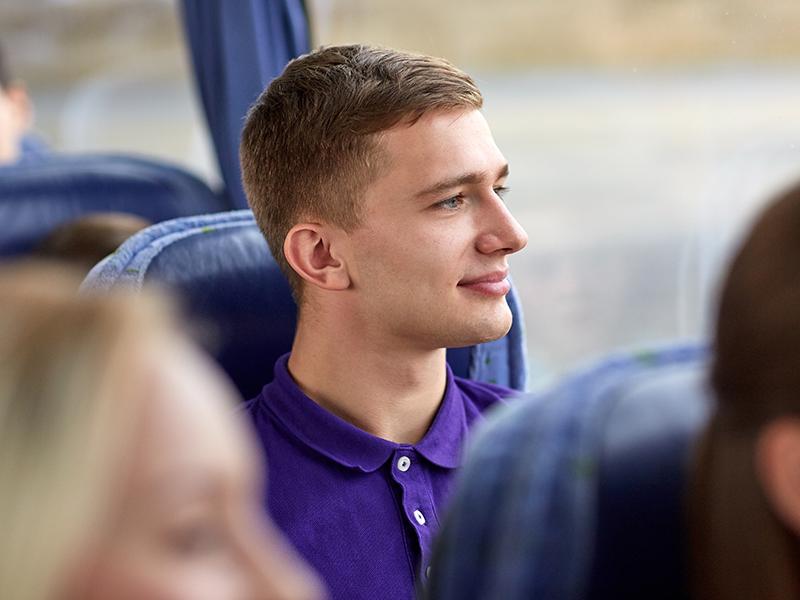 A young man sitting on a bus