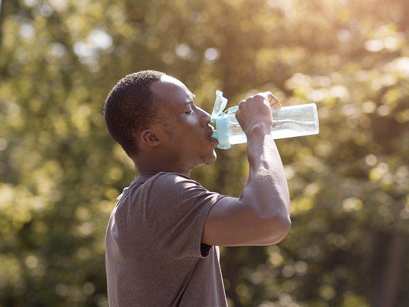 a person drinking water in the heat