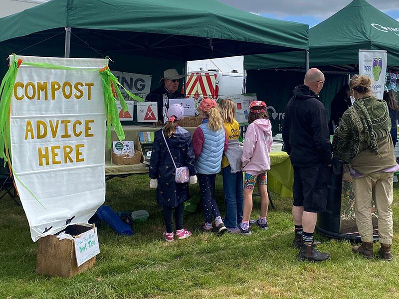 children reading leaflets at a compost stand
