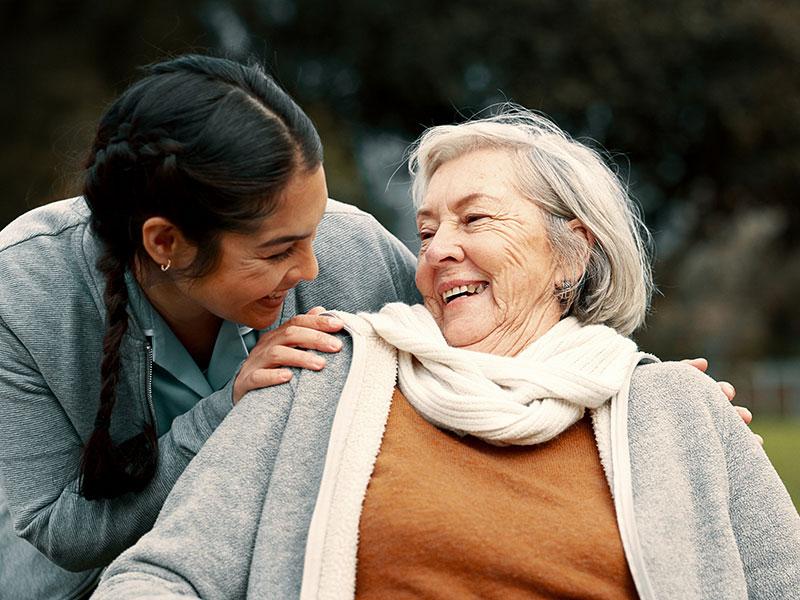 a female carer laughing with an older woman