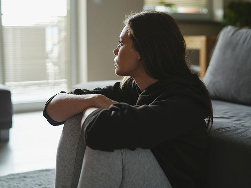 This shows a woman looking worried at home