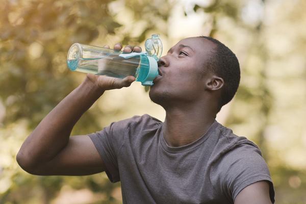 man drinking from a bottle of water