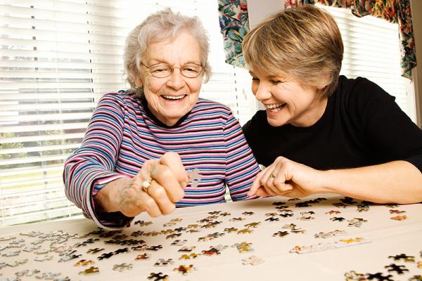 A younger and older woman doing a jigsaw