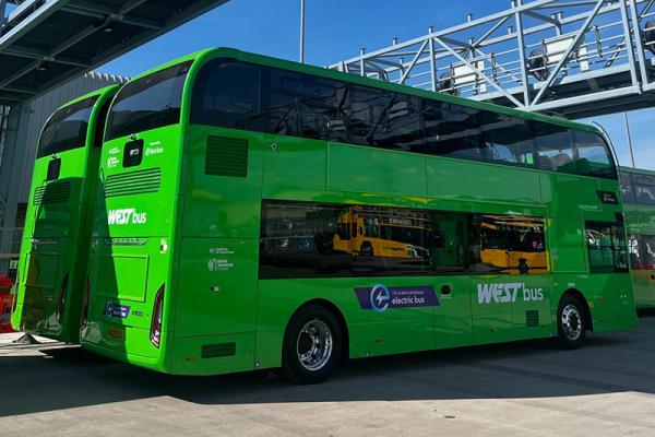 An image of a bright green electric bus parked in a bus depot