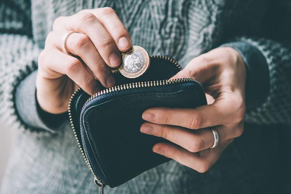 person putting money in purse