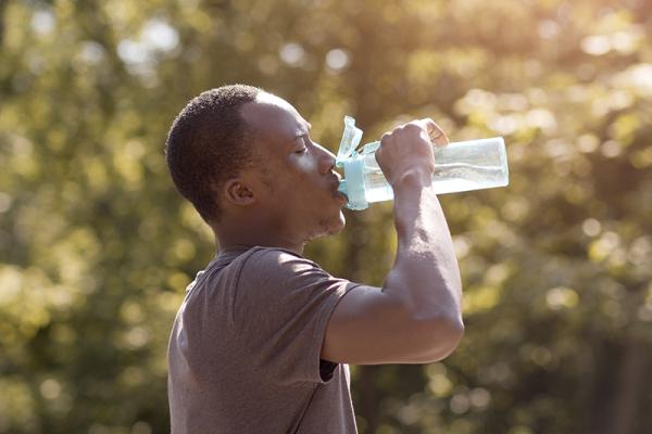 a person drinking water in the heat