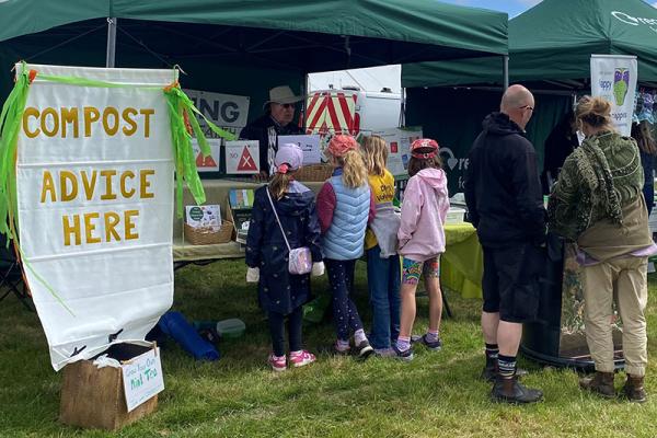 children reading leaflets at a compost stand