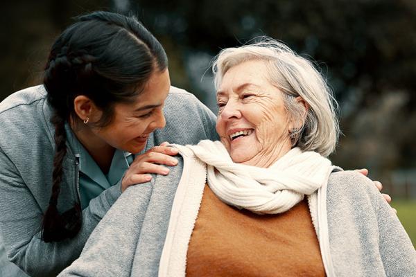 a female carer laughing with an older woman